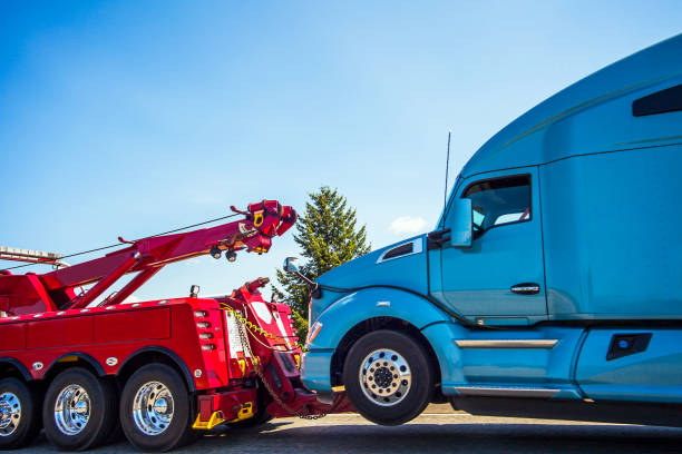a tow truck towing a red truck
