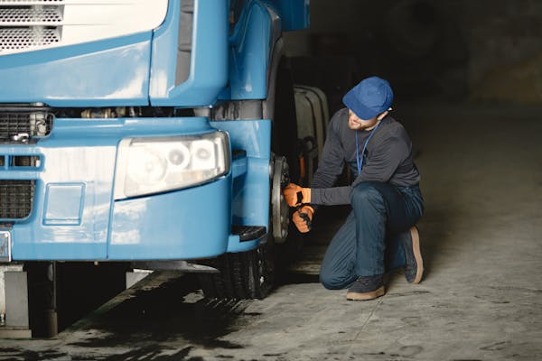 a person fixing a tire on a truck- about us page